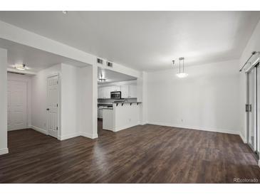 Bright living room features sleek floors and an open layout to the kitchen at 2575 S Syracuse Way # H206, Denver, CO 80231