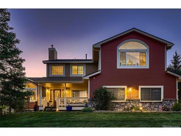 Charming home featuring a covered porch, well-manicured lawn, and a mix of siding and stone accents at 25779 E Jamison Cir, Aurora, CO 80016