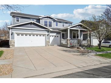 Two-story home with a three-car garage, covered porch, and a well-maintained front yard with concrete driveway at 12248 Kittredge St, Commerce City, CO 80603