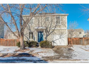 Two-story house with light beige siding, blue door, and attached garage at 1267 Bluejay Ave, Brighton, CO 80601