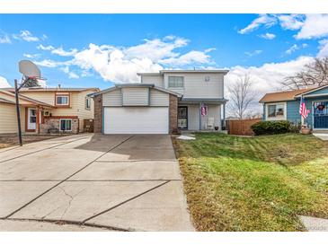 Two-story house with attached garage and landscaped lawn at 6119 Zenobia Ct, Arvada, CO 80003