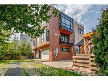 Contemporary brick home featuring attached garage, balcony, and modern architectural details at 3227 Quivas St # 1, Denver, CO 80211