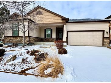 Charming single Gathering home with front yard landscaping and two car garage in winter at 12213 Joplin St, Commerce City, CO 80603