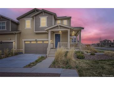 Charming home featuring a welcoming porch, well-manicured lawn, and attached garage, perfect for modern living at 17530 E 95Th Ave, Commerce City, CO 80022