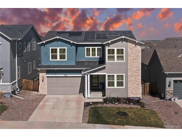 Beautiful two-story home featuring stone accents, a two-car garage, and solar panels against a colorful sky at 4757 Augustine Ct, Castle Rock, CO 80108