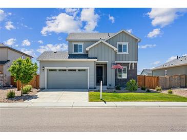 Charming two-story home with a well-manicured lawn, gray siding, and an attached two-car garage at 6954 E 117Th Ave, Thornton, CO 80233