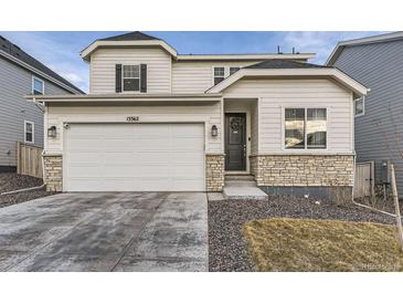 Charming home featuring a two-car garage, stone accents, manicured lawn, and welcoming front door at 13362 Amber Sky St, Parker, CO 80134