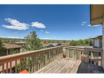Inviting back deck boasts wooden railings and panoramic views of the neighborhood and mountains beyond at 10528 Applebrook Cir, Highlands Ranch, CO 80130