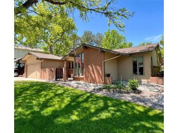 Charming home features a brick exterior, well-maintained lawn, garden and attached garage at 7019 S Windermere St, Littleton, CO 80120