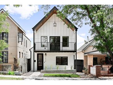 Charming two-story home with a striking white facade, balcony, and black trim at 3926 Kalamath St, Denver, CO 80211