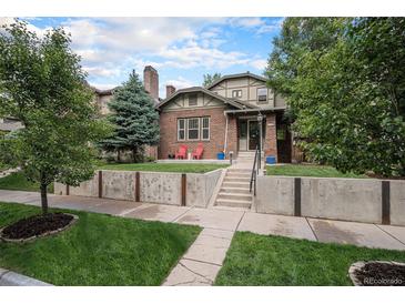 Charming brick two-story home with a well-manicured lawn and a concrete retaining wall at 726 S Corona St, Denver, CO 80209