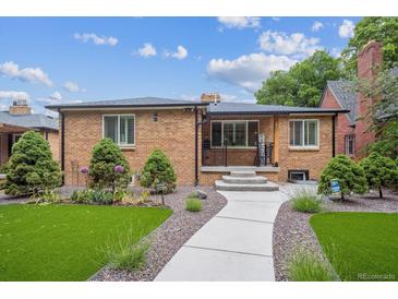 Charming brick home with manicured front yard featuring lush greenery, a welcoming walkway, and beautiful landscaping at 2664 Forest St, Denver, CO 80207