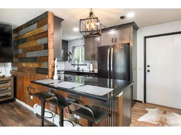 Charming kitchen featuring a black refrigerator, cabinets, countertops, and bar stool seating at 2700 S Holly St # 202, Denver, CO 80222