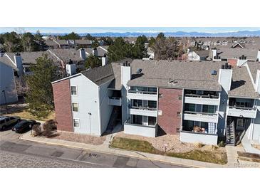 Exterior view of a multi-story home featuring brick accents, balconies, and a well-maintained landscape at 14495 E 1St Dr # C1, Aurora, CO 80011
