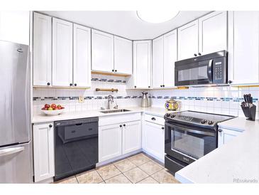 Efficient kitchen featuring white cabinets, black appliances, and tile backsplash at 9150 E Center Ave # 9C, Denver, CO 80247