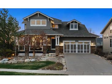 Charming two-story home featuring stone accents, a two-car garage, and a well-manicured front yard at 12187 S Hidden Trail Ct, Parker, CO 80138
