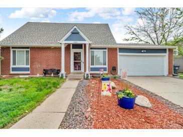 Charming brick home with well-manicured lawn, walkway and two car garage at 4694 S Ouray Way, Aurora, CO 80015