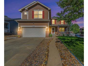 Charming two-story home featuring a well-manicured lawn, inviting porch, and a two-car garage at 10289 Dresden St, Firestone, CO 80504