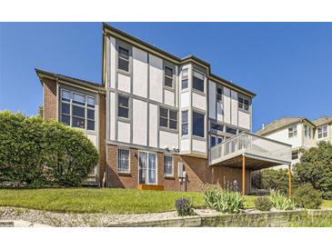 View of the exterior showing a multi-story house, backyard with garden, a deck and a lawn area at 16261 W Ellsworth Ave, Golden, CO 80401