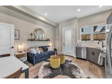 Cozy living room with a blue sofa, industrial style shelf, and decorative mirror and furnishings at 3219 W 19Th Ave # 4, Denver, CO 80204