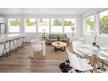 Bright living room featuring large windows, modern furniture, and open layout with dining area at 5462 S Cedar St, Littleton, CO 80120