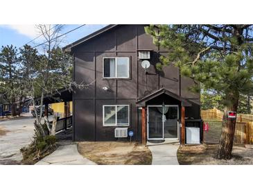 Charming home featuring a covered porch and lush landscaping, perfect for enjoying the outdoors at 3046 S Alpine Dr, Evergreen, CO 80439
