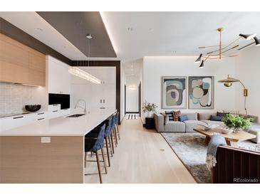 Modern kitchen with white and wood cabinets, large island, and high-end appliances at 1901 Wazee St # 1401, Denver, CO 80202