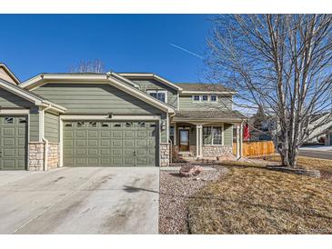 Charming two-story home with a well-maintained lawn, a two-car garage, and stone accents at 3938 Lazy K Dr, Castle Rock, CO 80104