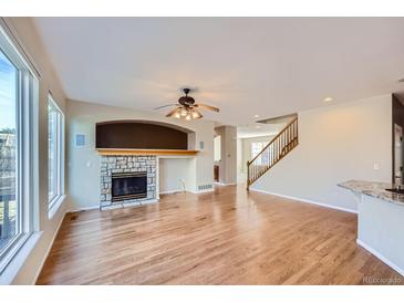 Spacious living room featuring a fireplace with stone surround and hardwood flooring at 3938 Lazy K Dr, Castle Rock, CO 80104