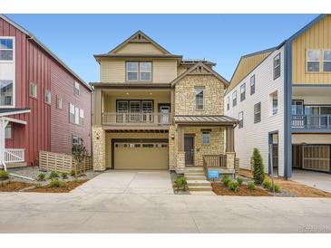 Two-story home with stone and wood accents, a front porch, and an attached two-car garage at 7307 Waterleaf Trl, Littleton, CO 80125