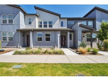 Modern townhome showcasing a contemporary architectural style, neat landscaping, and a welcoming walkway at 19221 E 65Th Ave, Denver, CO 80249