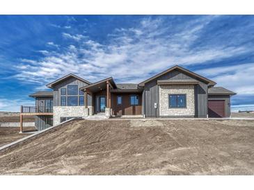 New construction with wood and stone details and large windows on a sloped lot at 1740 Joseph Cir, Elizabeth, CO 80107