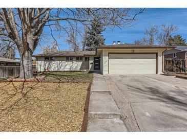Ranch-style home with a two-car garage, manicured lawn, and a large tree in the front yard at 2955 E Caley Ave, Centennial, CO 80121