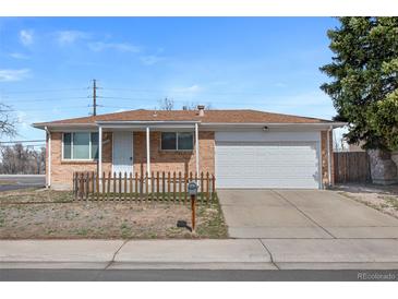 Charming brick home featuring an attached garage and a well-maintained front yard at 12501 Randolph Pl, Denver, CO 80239