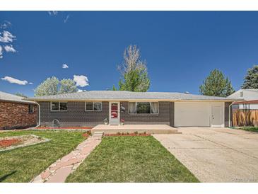 Charming brick home featuring a lush lawn, stone walkway, and attached two-car garage at 8361 Mason Cir, Westminster, CO 80031