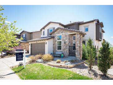 Charming two-story home featuring stone accents, a well-maintained lawn, and a cozy front porch area at 15194 W Washburn Ave, Lakewood, CO 80228