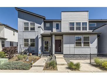 Stylish townhouse showcases modern design, landscaping, and inviting walkway to the front door at 16057 E 47Th Pl, Denver, CO 80239