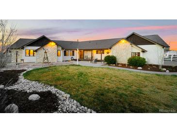 Beautiful single-story home with stone accents, well-kept lawn, and cozy patio area, perfect for outdoor living at 451 W 152Nd Ave, Broomfield, CO 80023