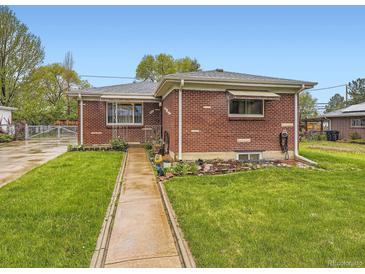 Charming brick home with a well-maintained front yard and inviting walkway at 5721 Everett St, Arvada, CO 80002