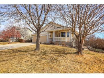 Charming home featuring a covered front porch and well-maintained lawn at 6295 Clayton Cir, Frederick, CO 80530