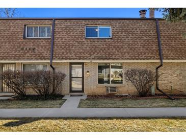 Charming exterior elevation of a two-story townhome with brick and lush green lawn at 13003 W 20Th Ave, Golden, CO 80401