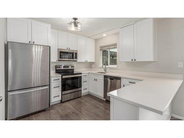 Modern kitchen features stainless steel appliances, white cabinets, and light countertops at 3667 W Union Ave # 2E, Denver, CO 80236