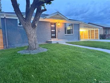 Charming single-story home with a well-manicured lawn, stylish carport, and modern front door at 7126 Joan St, Denver, CO 80221