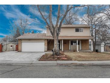 Charming two-story home with brick accents, covered porch, and well-maintained front yard at 13778 W 71St Pl, Arvada, CO 80004