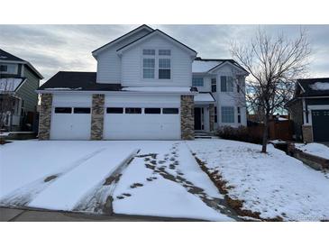 Two-story house with three-car garage and snow-covered driveway at 5755 S Zante Cir, Aurora, CO 80015