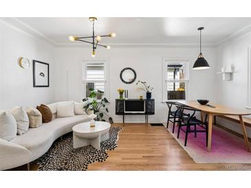 Bright, modern living room featuring a curved sofa, designer lighting, and stylish decor at 1705 S Downing St, Denver, CO 80210