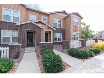 Beautiful townhome with manicured lawn and charming brick accents near the front entrance at 15443 W 65Th Ave # B, Arvada, CO 80007