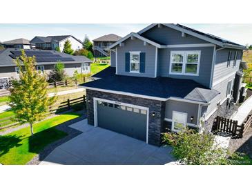 Two-story home with gray siding, stone accents, and a two-car garage at 26994 E Indore Ave, Aurora, CO 80016
