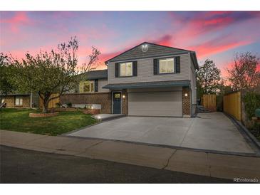Charming two-story home with brick accents, a spacious driveway, and a well-manicured lawn at 4924 S Flower Way, Littleton, CO 80123