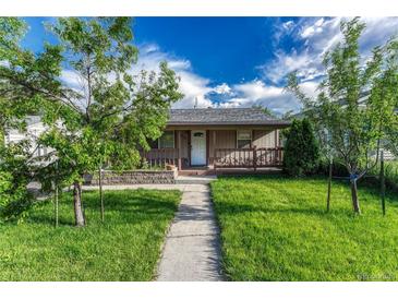 Charming home with a well-manicured lawn and inviting front porch, perfect for relaxing outdoors at 3090 W Longfellow Pl, Denver, CO 80221